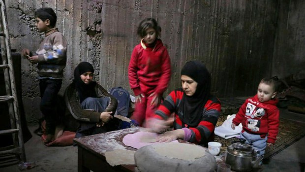 نساء يخبزن خبزا لأبنائهن في قبو من أقبية الغوطة الشرقية