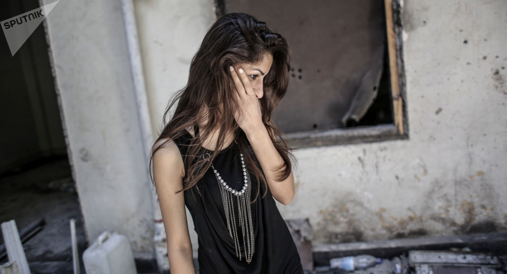 فتاة تتفحّص منزلها في حمص وسط الركام/ سبوتنيك
