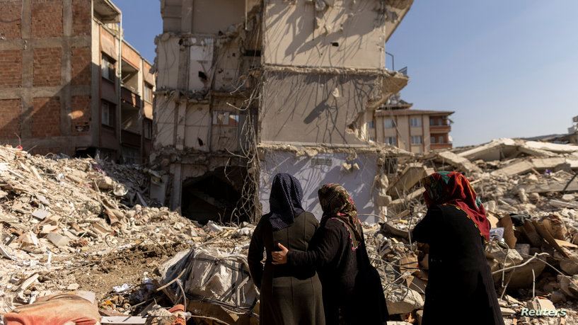 Women look at what is left of their home following the deadly earthquake in Hatay province, Turkey, February 14, 2023. REUTERS/Eloisa Lopez