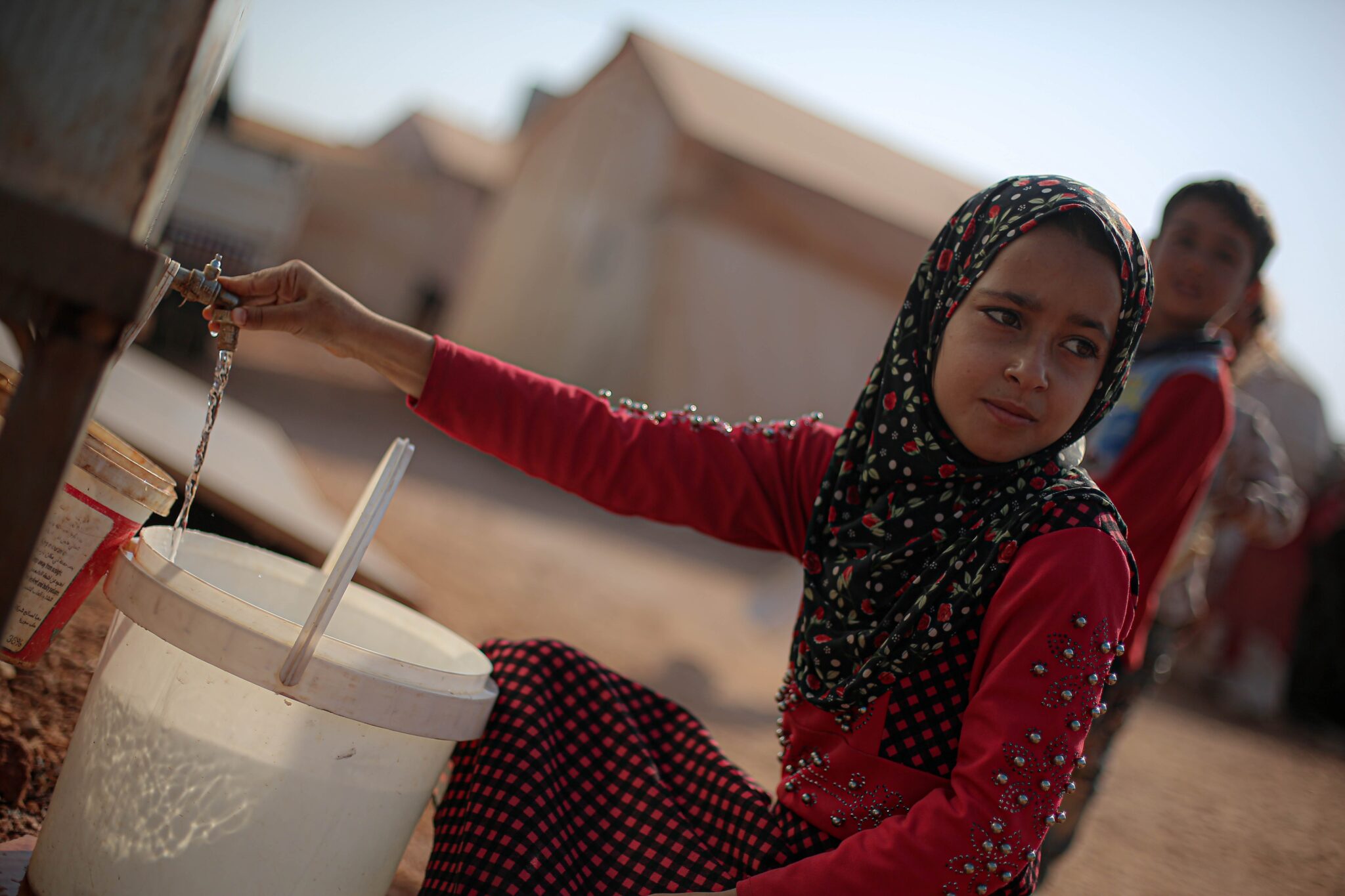 فتاة سورية تملأ الماء من الصنبور/ المصدر: Khaled Akacha, Pexel