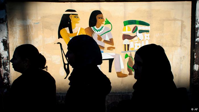 نساء مصريات أمام لوحة فرعونية/ AP