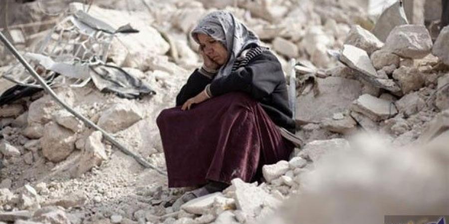 أم سورية تجلس فوق أنقاض منزلها المدمّر/ أرشيف