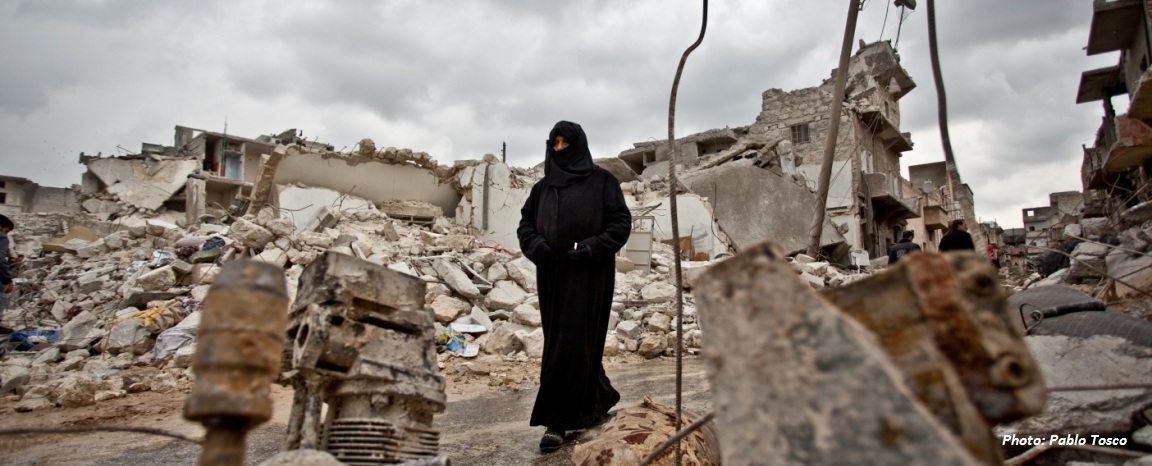 إمرأة بجانب أنقاض بيتها في حلب