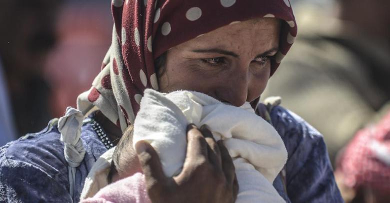 إمرأة سورية لاجئة تحتضن طفلها