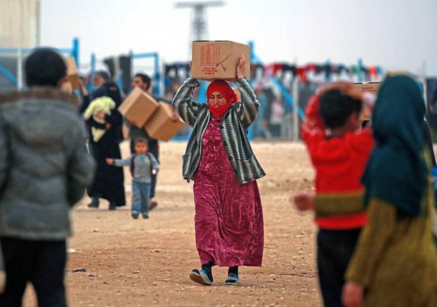 نازحة/ لاجئة سوريّة تحمل سلّةً إغاثية (أرشيف)